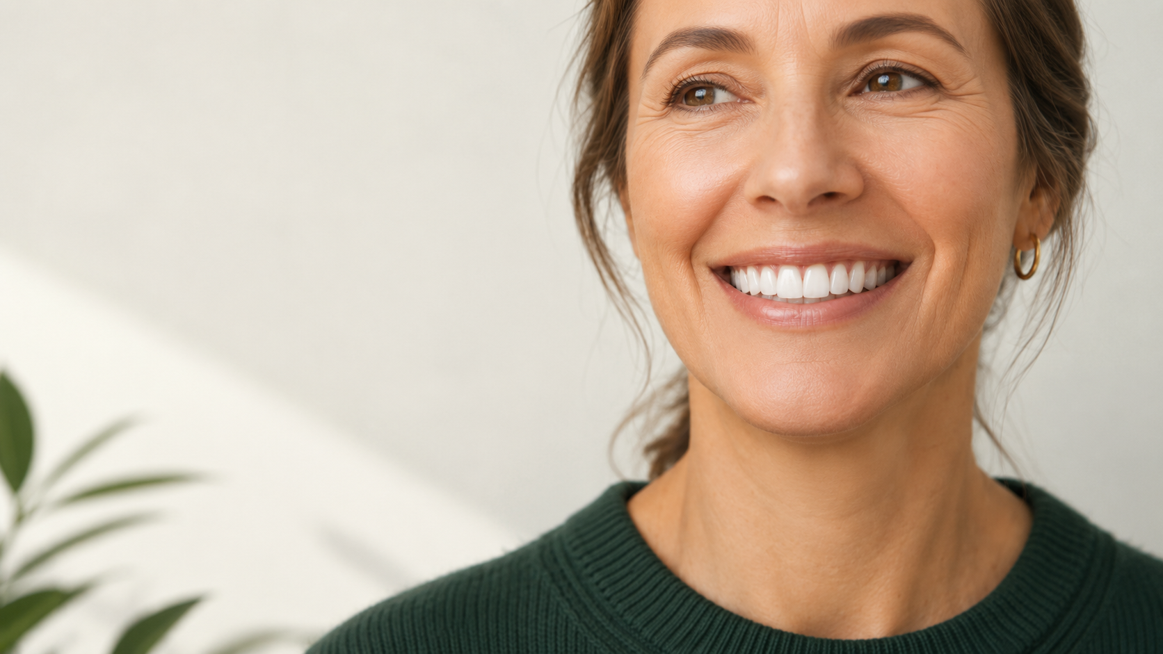 A smiling woman in a dark green sweater.